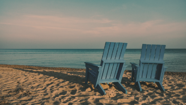 two blue chairs on a beach retirement