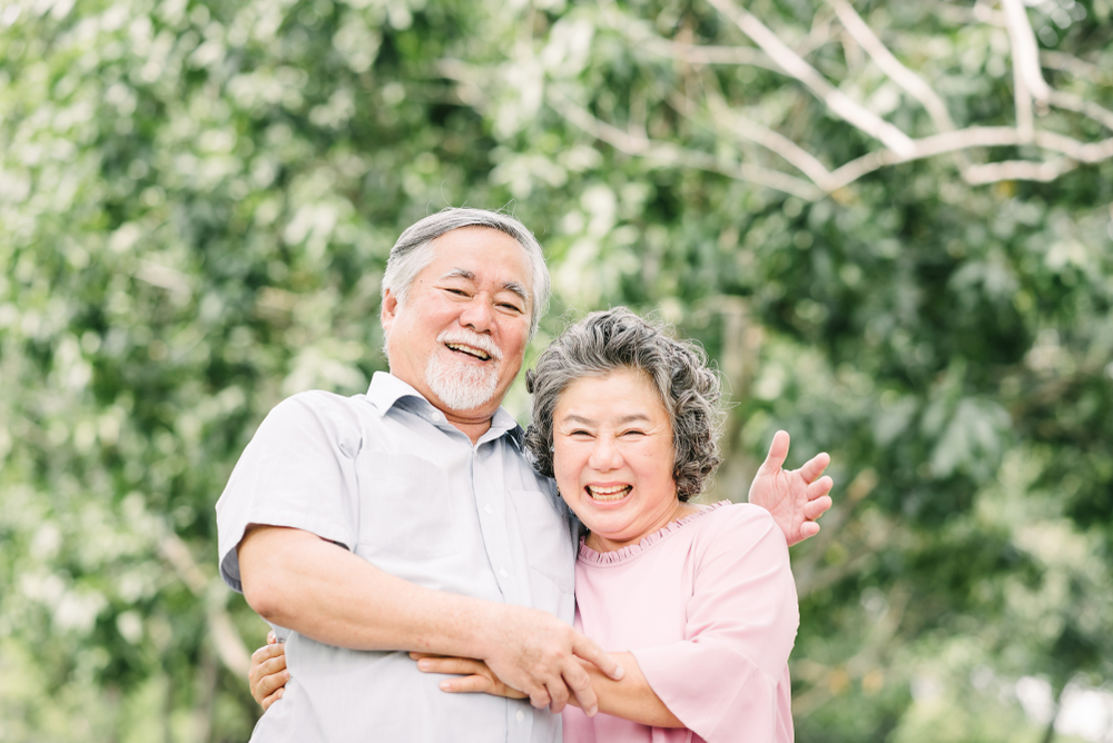 senior asian couple smiling while embracing each other life insurance