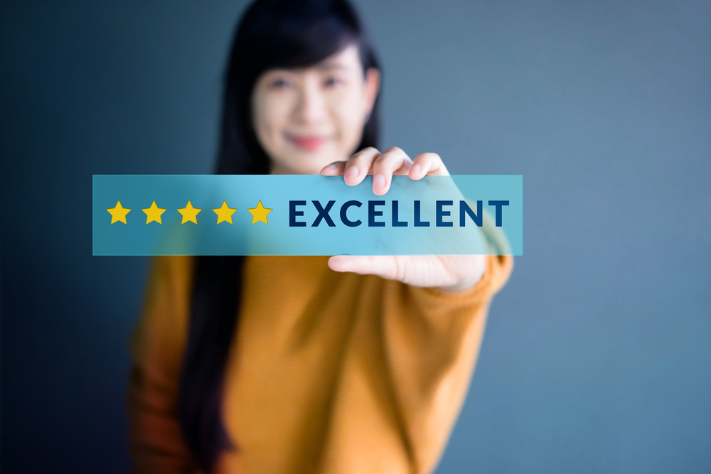 client holding up her 5-star review of financial advisor