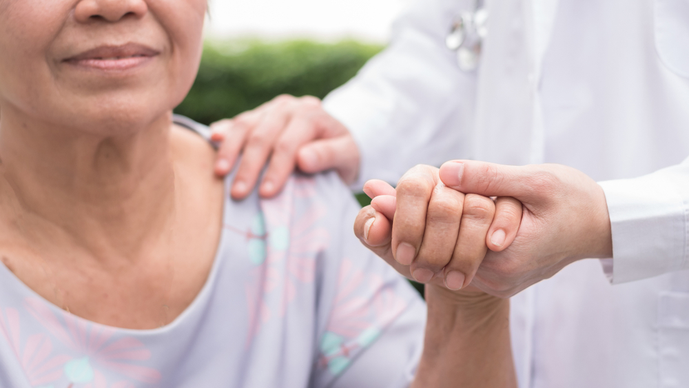 elderly woman being helped by her caregiver