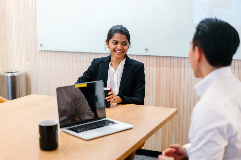 young woman getting performance review from young man