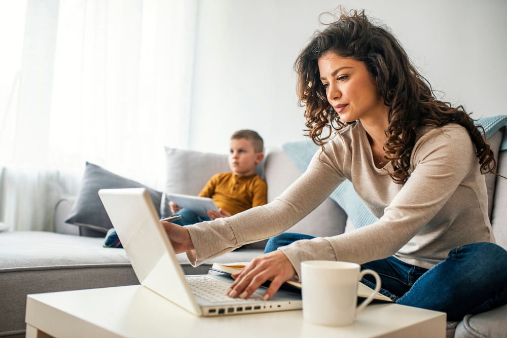 woman doing her finances with child in background