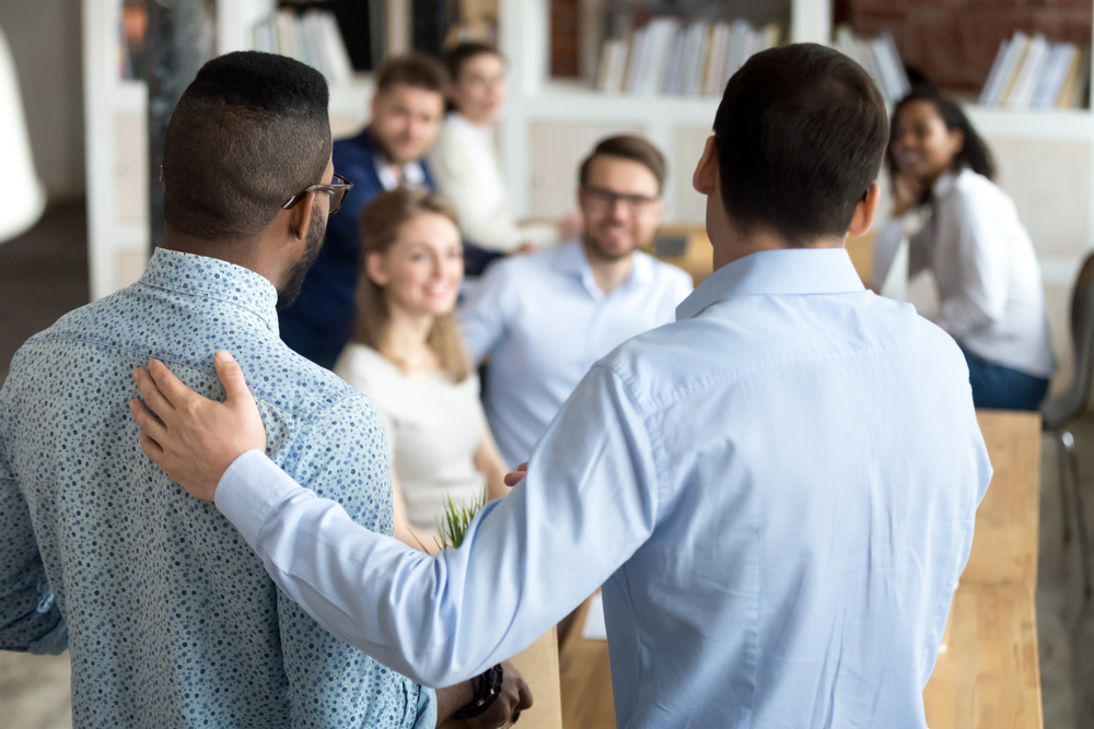 new employee having first working day in company standing in front of colleagues, executive manager employer introducing welcoming newcomer to workmates